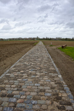 route r&eacute;fectionner en pav&eacute; emprunt&eacute; par la course cycliste du paris Roubaix secteur Templeuve avec un ciel gris mena&ccedil;ant
