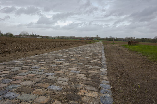 route r&eacute;fectionner en pav&eacute; emprunt&eacute; par la course cycliste du paris Roubaix secteur Templeuve avec un ciel gris mena&ccedil;ant