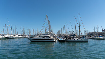 Fototapeta premium Luxury yachts and sailboats moored in marina under clear blue sky