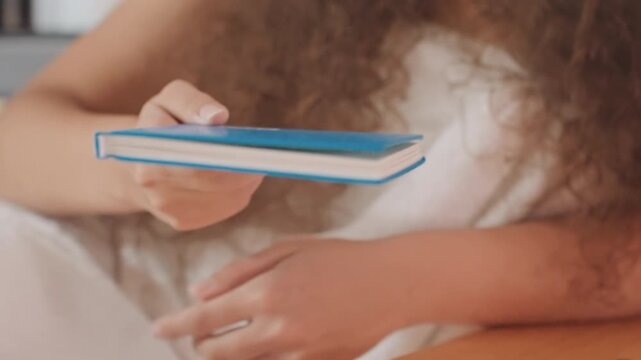 Guest opening colorful planner hotel room pages, stickered spread revealed and fingers pointing at layout. Playful planning scene with notes and markers, closing notebook and placing on bedside table