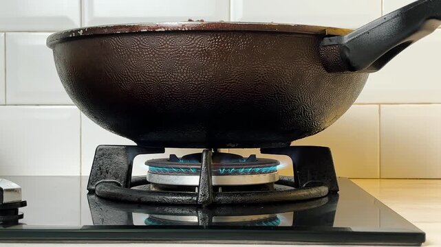A gas stove with a blue propane flame. A typical cooking routine.