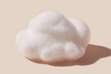 Fototapeta premium Foam bubble on beige surface with soft shadow, close up texture of white soap foam for cleaning, skincare or cosmetic product concept with smooth and airy appearance.