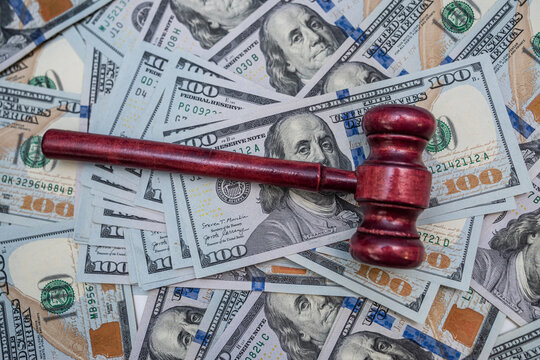 Judge Gavel Resting on One Hundred US Dollar Bills for Legal Compensation and Lawsuit Concept