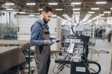 Factory worker inspecting aluminum profile manufacturing process
