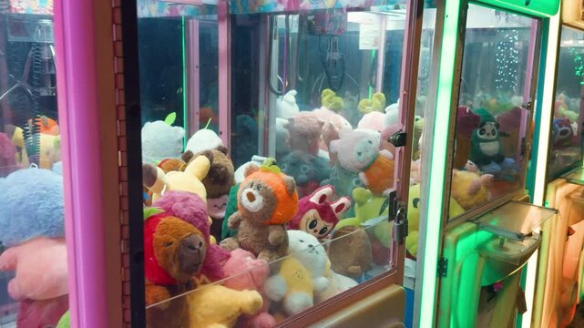 Claw machine arcade game filled with various colorful plush toys and stuffed animals, generating excitement and challenge for players trying to win a prize at an entertainment center