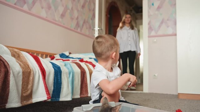 Young boy concentrating on building blocks game. Little child deeply involved in constructive play activity. Young boy practices independent skills through focused play with building and toys