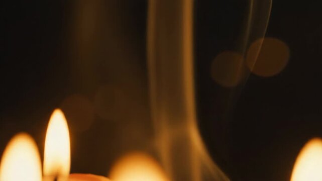 Group of burning candles and matchboxes creating a solemn atmosphere for prayer or memorial vigil.