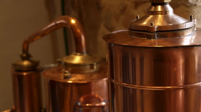 Copper absinthe still in distillery with warm light and metal reflections
