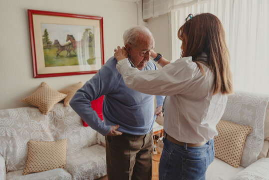 Daughter helping senior father dressing at home