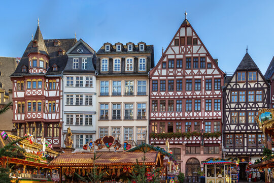 Christmas market on Romerberg square in Frankfurt am Main Germany. Traditional wooden stalls in daylight under blue sky
