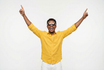 Naklejka premium Young black man celebrating with raised arms and cheerful expression 