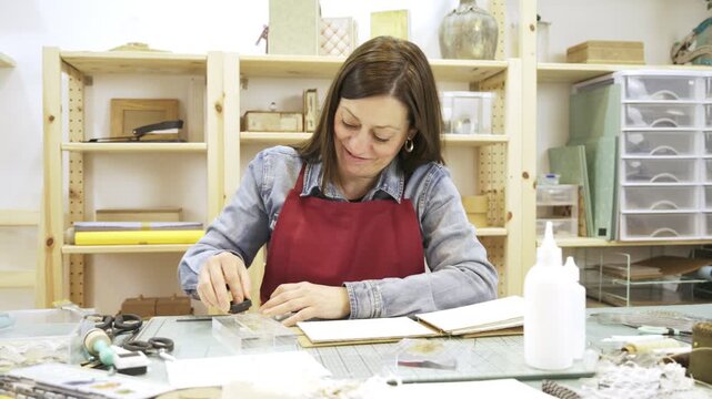 Woman creating a personalized scrapbook album at home