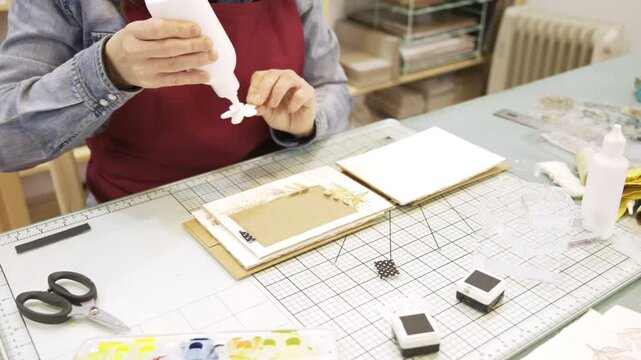 Woman creating a personalized handmade scrapbook album