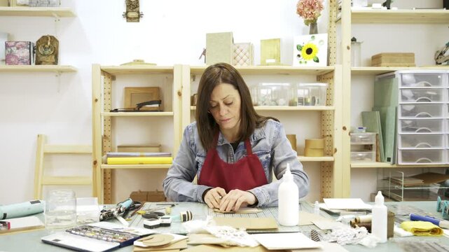 Woman creating a personalized scrapbook at her desk