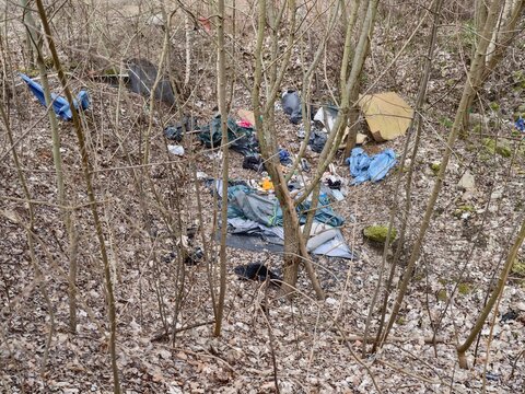 Littered campsite scene. Disused camping items reveal trespassing and environmental abandonment