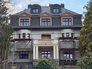 Urban renewal project involving restoring historic mansion with scaffolding and preservation measures © Vladimir