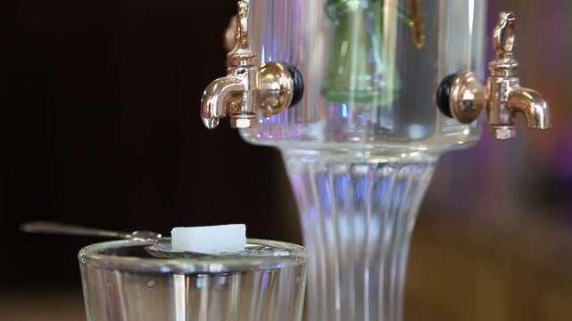 Slow motion absinthe preparation with dripping water on sugar cube