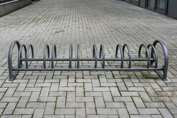 Wide Empty Bicycle Parking In Courtyard With Long Row Of Steel Loops, Expansive Paving And Muted Sky, Shows Sustainable Mobility Infrastructure Awaiting Commuters, Clean Geometry And Civic Space © Ekaterina