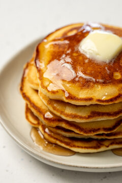 Stack of pancakes on a ceramic plate on a light surface 
