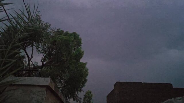 A dark scene featuring a lightening & thunder faintly illuminated object with a noticeable reflection and subtle highlights in the background