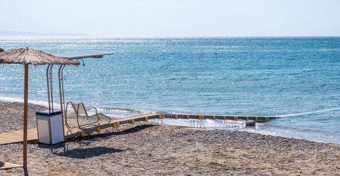 Floating accessibility path from sandy beach into blue sea, safe wheelchair access, Chios island Greece