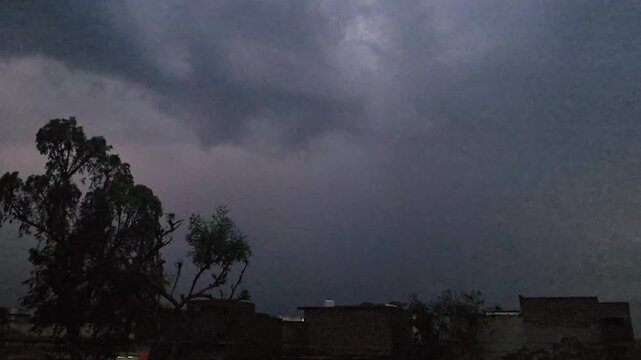 A dark scene featuring a lightening & thunder faintly illuminated object with a noticeable reflection and subtle highlights in the background