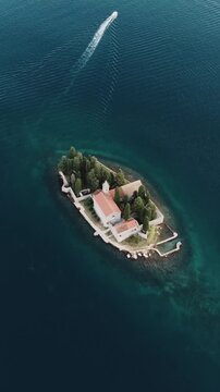 Small monastery island with church surrounded by turquoise sea, aerial drone view of Kotor Bay, Montenegro