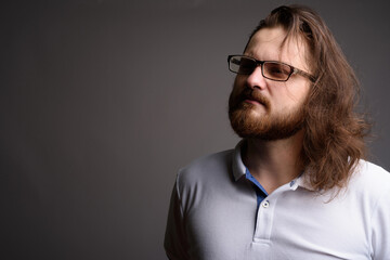 Obraz premium Pensive Bearded Man with Long Hair and Glasses Looking Away - Thinking Concept