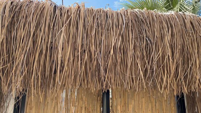 Thatch roof and bamboo wall create rustic architectural background