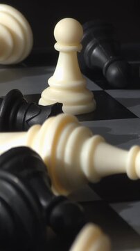 Last pawn standing: Macro shot of fallen chess pieces after battle