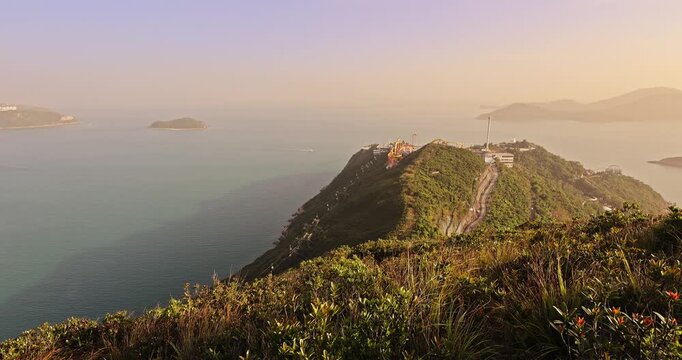 Aerial view of Ocean Park theme park on green hill. Coastal landscape with islands and sea at sunset. Hong Kong travel destination.