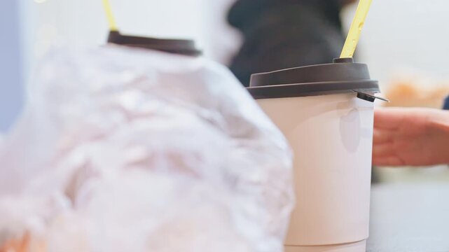 Child examines drink with curiosity. Young child explores beverage attentively during cafe visit. An enthusiastic young child tastes and inspects his beverage thoughtfully at bustling cafe