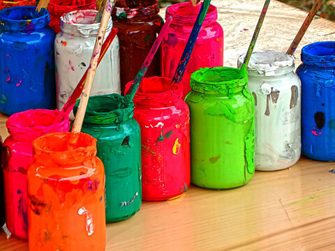 Jars with colors put on a table.