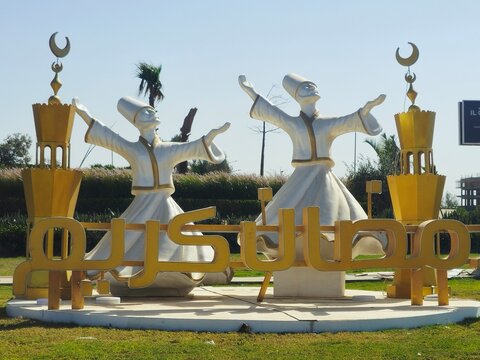 Cairo, Egypt, March 20 2026: a festive sculpture, celebrating the Islamic holy month of Ramadan, with two figures performing a traditional whirling dervish dance, minarets topped with crescent moons
