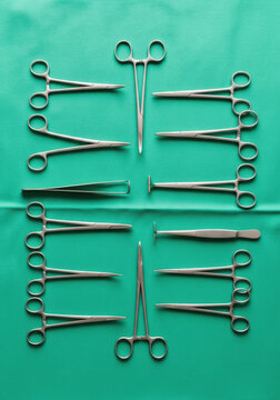 Surgical instrument forceps hemostat clamp tweezers stainless steel green drape symmetry arranged medical
