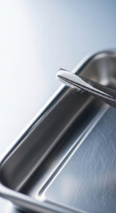 Sterile metal tray silver tweezers cotton swab medical preparation bright clinical lighting calm professional care