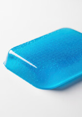Blue cooling gel patch textured surface with soft studio light and water droplets conveying soothing relief