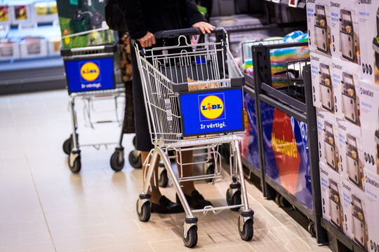 RIGA, LATVIA. 12th March 2026. A customer pushes a metal shopping cart featuring the Lidl logo