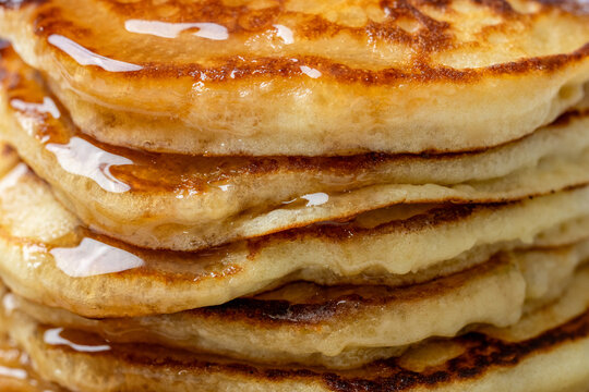 Close-up of a stack of pancakes on a ceramic plate on a light surface 