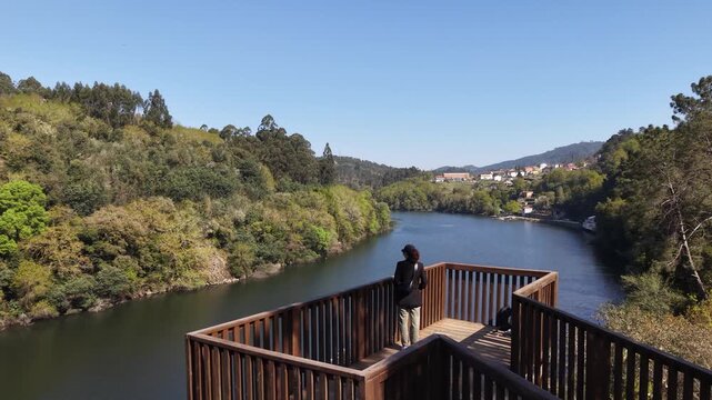 River reflecting a hotel and restaurant building surrounded by a forest in galicia, spain