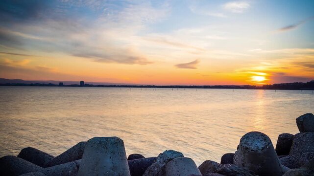 Breakwater against the background of a cloudy sky and the Black Sea with waves