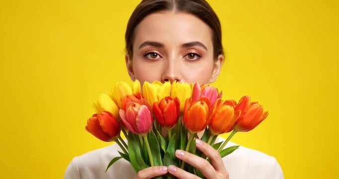 Blooming Delight: A woman holds a vibrant bouquet of multicolored tulips, bringing a splash of joy and freshness to the scene, perfect for springtime or any moment celebrating beauty.