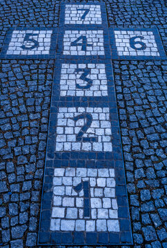 Hopscotch number pattern on urban pavement, outdoor children's game.