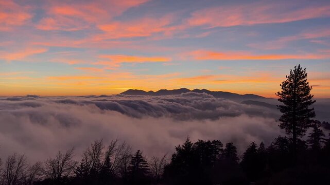 Fog Rolling over Mountains Pink Sunset. 