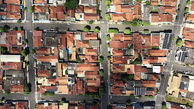 Aerial video footage of a densely populated urban neighborhood with red roofs and city streets