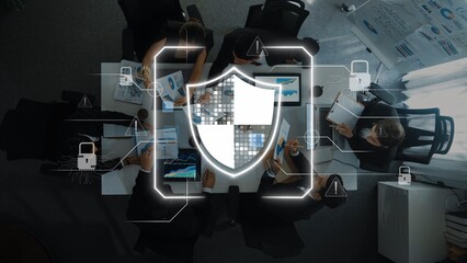A team of professionals engages in a strategic meeting on cybersecurity, using digital devices surrounded by data visuals, emphasizing protection and teamwork. Raster © InfiniteFlow