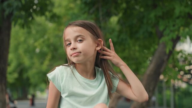 Multiracial daughter portrait in green park, closeup with direct gaze and braided curly hair, mint shirt and soft bokeh trees, natural light and calm expression, family moment vibe