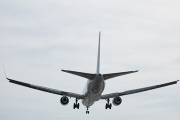 Obraz premium A huge passenger plane is landing in airport of Phuket, Thailand, a bottom view 