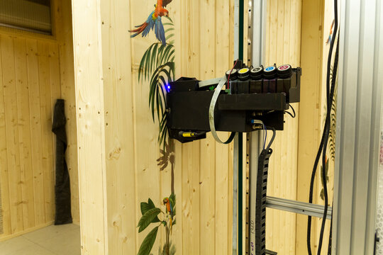 The device in the image is a vertical wall printer, a specialized inkjet printer designed to print directly onto vertical surfaces like walls. Technology
