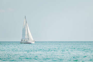 Sailboat on a sunny summer day. Couple on sailing vessel cruising the blue water of the Gulf of America, Florida. © Scott Habermann